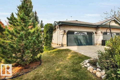 View of side of home featuring a yard, concrete driveway, and an attached garage - 112 Haddow Close, Edmonton, AB - Outdoor