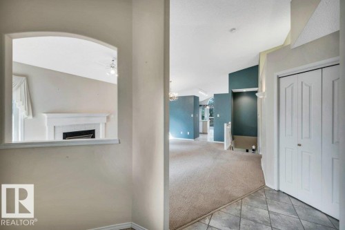 Hallway with light colored carpet, light tile patterned floors, hanging lights, and an upstairs landing - 112 Haddow Close, Edmonton, AB - Indoor Photo Showing Other Room