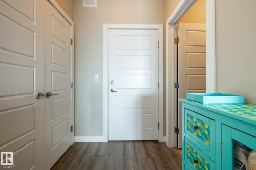 Foyer entrance featuring dark wood-style floors and baseboards - 407 2590 Anderson Way, Edmonton, AB - Indoor Photo Showing Other Room