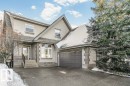 View of front of property with asphalt driveway, an attached garage, stone siding, and stucco siding - 1579 Hector Road, Edmonton, AB  - Outdoor 
