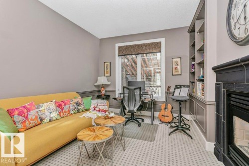 Office space with a fireplace, wainscoting, and a textured ceiling - 1579 Hector Road, Edmonton, AB - Indoor With Fireplace