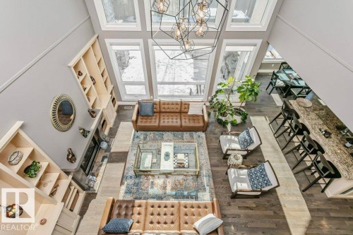 Living room with dark wood-type flooring, a high ceiling, and a chandelier - 1579 Hector Road, Edmonton, AB - Indoor Photo Showing Other Room
