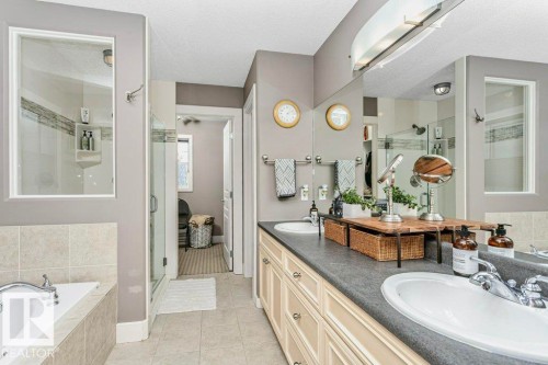 Bathroom featuring a shower stall, double vanity, a textured ceiling, light tile patterned floors, and a bath - 1579 Hector Road, Edmonton, AB - Indoor Photo Showing Bathroom