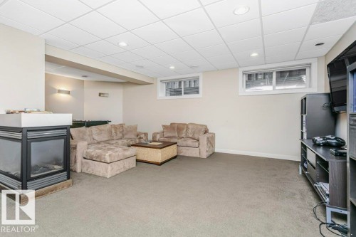 Living room with a paneled ceiling, light colored carpet, and recessed lighting - 1579 Hector Road, Edmonton, AB - Indoor Photo Showing Other Room With Fireplace