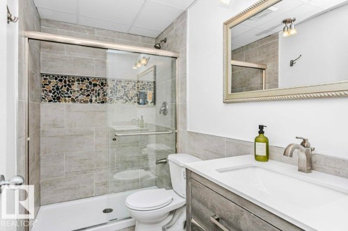 Bathroom featuring vanity, a stall shower, and tile walls - 1579 Hector Road, Edmonton, AB - Indoor Photo Showing Bathroom