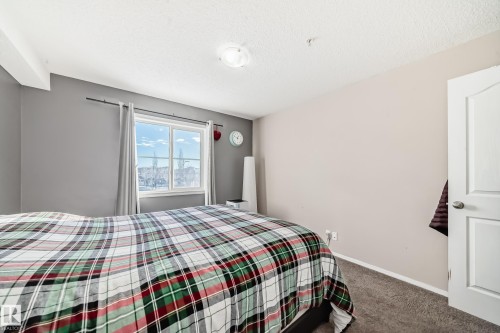 Carpeted bedroom featuring baseboards and a textured ceiling - 302 530 Watt Boulevard Sw, Edmonton, AB - Indoor Photo Showing Bedroom