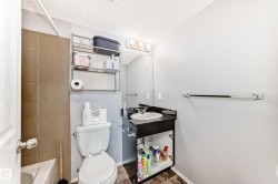 Bathroom with vanity, a textured ceiling, and  shower combination - 