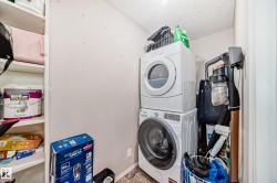 Laundry area featuring stacked washer / dryer and a textured ceiling - 