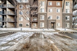 Snow covered building with a view of apartment building / complex - 