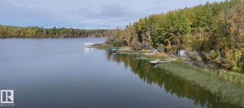 Water view with a heavily wooded area and a boat dock - 34 Ella Mae Crescent, Rural Athabasca County, AB - Outdoor With Body Of Water With View