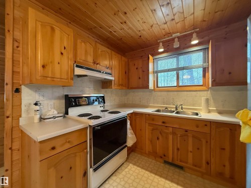Kitchen with electric range, light floors, light countertops, under cabinet range hood, and track lighting - 34 Ella Mae Crescent, Rural Athabasca County, AB - Indoor Photo Showing Kitchen With Double Sink