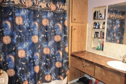 Bathroom with a shower with shower curtain, vanity, and backsplash - 