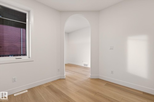 Spare room with arched walkways and light wood finished floors - 9 Elwyck Gate, Spruce Grove, AB - Indoor Photo Showing Other Room