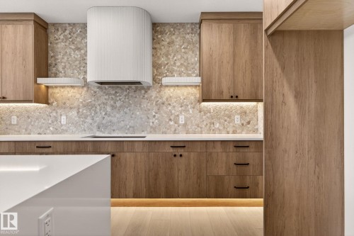 Kitchen featuring wood finish cabinets, tasteful backsplash, modern cabinets, and light wood-style floors - 9 Elwyck Gate, Spruce Grove, AB - Indoor