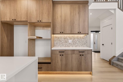 Kitchen featuring decorative backsplash, light wood-style flooring, recessed lighting, light stone countertops, and modern cabinets - 9 Elwyck Gate, Spruce Grove, AB - Indoor