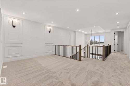 Empty room featuring suspended lighting and light carpet - 9 Elwyck Gate, Spruce Grove, AB - Indoor Photo Showing Other Room