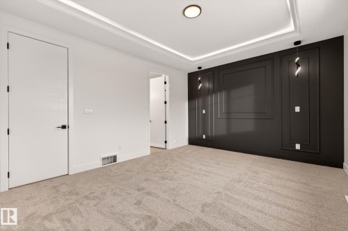 Unfurnished bedroom featuring light carpet and a tray ceiling - 9 Elwyck Gate, Spruce Grove, AB - Indoor Photo Showing Other Room