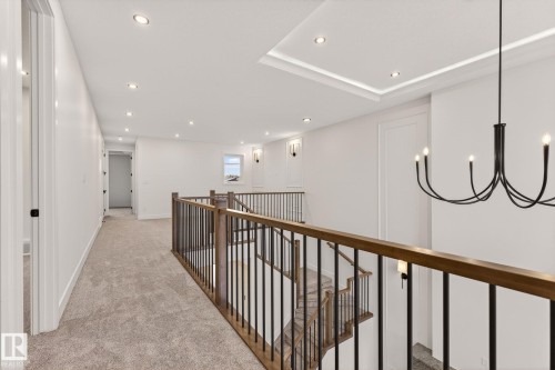 Hallway featuring light carpet, an upstairs landing, and a chandelier - 9 Elwyck Gate, Spruce Grove, AB - Indoor Photo Showing Other Room