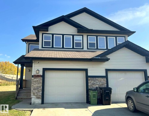 View of front facade featuring stone siding, concrete driveway, and a shingled roof - 3705 11 Street, Edmonton, AB - Outdoor