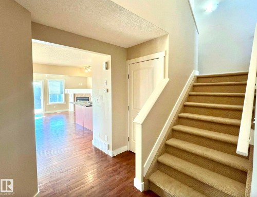 Stairway featuring a textured ceiling, hardwood / wood-style flooring, and a fireplace - 3705 11 Street, Edmonton, AB - Indoor Photo Showing Other Room