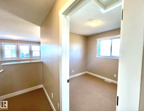 Corridor with carpet floors, a textured ceiling, and an upstairs landing - 3705 11 Street, Edmonton, AB - Indoor Photo Showing Other Room