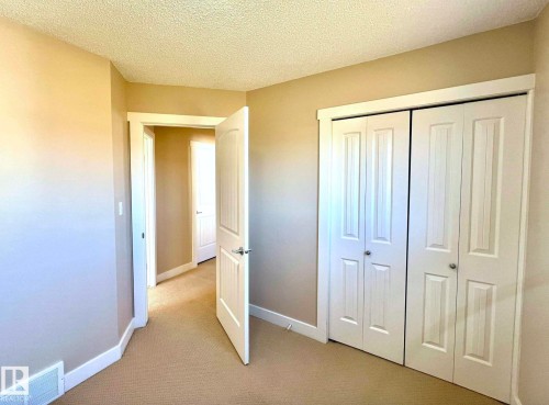 Unfurnished bedroom featuring carpet floors, a closet, and a textured ceiling - 3705 11 Street, Edmonton, AB - Indoor Photo Showing Other Room