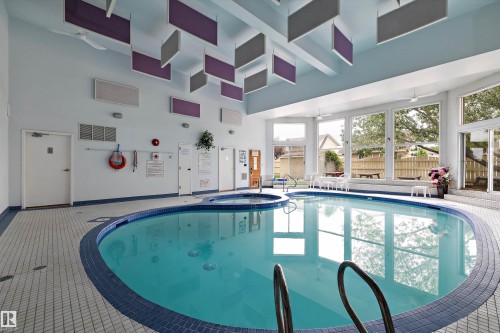 View of pool with a connected hot tub and ceiling fan - 218 18012 95 Avenue, Edmonton, AB - Indoor Photo Showing Other Room With In Ground Pool