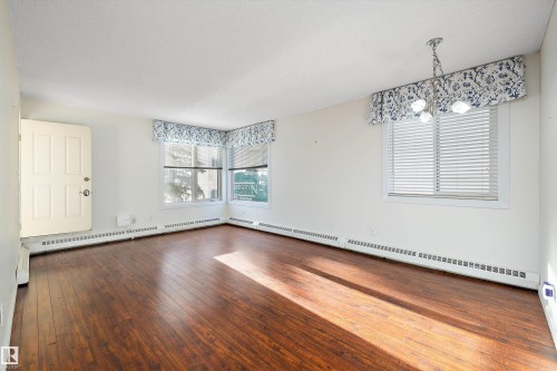 Dining room with vinyl plank flooring and chandelier - 218 18012 95 Avenue, Edmonton, AB - Indoor Photo Showing Other Room