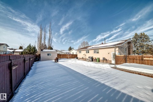 Snowy yard featuring a fenced backyard, a gate, and an outdoor structure - 12203 147 Avenue, Edmonton, AB - Outdoor