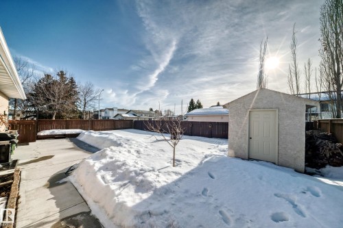 Yard covered in snow featuring a fenced backyard and a shed - 12203 147 Avenue, Edmonton, AB - Outdoor