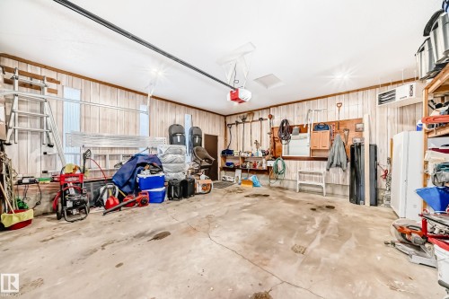 Garage featuring a heating unit, freestanding refrigerator, and a garage door opener - 12203 147 Avenue, Edmonton, AB - Indoor Photo Showing Garage