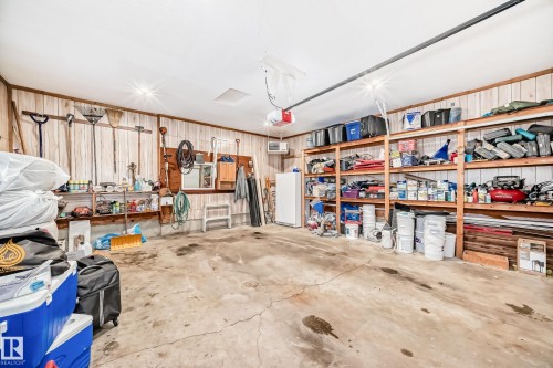 Garage featuring freestanding refrigerator, a heating unit, and a garage door opener - 12203 147 Avenue, Edmonton, AB - Indoor Photo Showing Garage