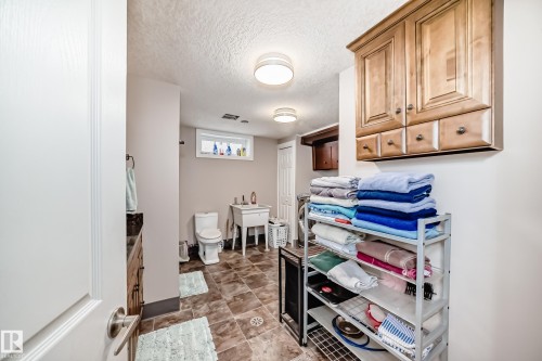 Laundry room with a textured ceiling and cabinet space - 12203 147 Avenue, Edmonton, AB - Indoor Photo Showing Other Room
