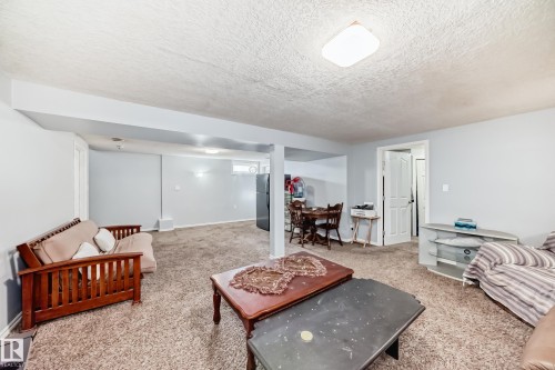 Living room featuring a textured ceiling and carpet floors - 12203 147 Avenue, Edmonton, AB - Indoor Photo Showing Living Room