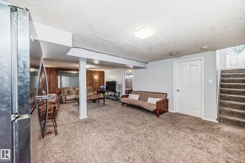 Living area with a textured ceiling and light colored carpet - 12203 147 Avenue, Edmonton, AB - Indoor