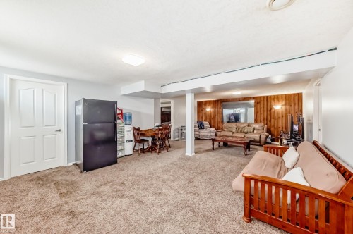 Living area with wooden walls and light carpet - 12203 147 Avenue, Edmonton, AB - Indoor