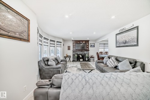 Living area featuring a stone fireplace, healthy amount of natural light, recessed lighting, and wood finished floors - 12203 147 Avenue, Edmonton, AB - Indoor