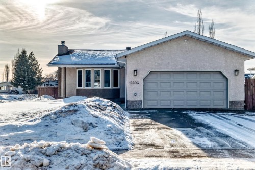 Ranch-style home with stucco siding, a chimney, an attached garage, and driveway - 12203 147 Avenue, Edmonton, AB - Outdoor