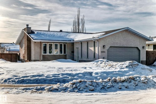 Ranch-style home featuring a chimney, stucco siding, and an attached garage - 12203 147 Avenue, Edmonton, AB - Outdoor