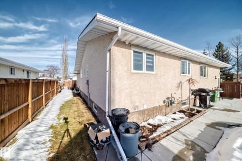 Back of house with a fenced backyard, stucco siding, and a patio area - 12203 147 Avenue, Edmonton, AB - Outdoor With Exterior
