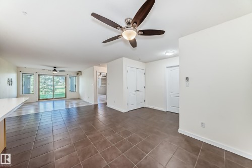 Unfurnished room with a ceiling fan and dark tile patterned floors - 125 278 Suder Greens Drive, Edmonton, AB - Indoor Photo Showing Other Room