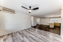Unfurnished living room with dark wood-type flooring, a ceiling fan, and a wall mounted mini split - 