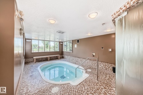 View of swimming pool with an in-ground hot tub, a sunroom, and patio surround - 125 278 Suder Greens Drive, Edmonton, AB - Indoor Photo Showing Other Room