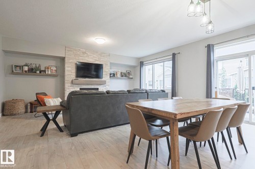 Dining room featuring light wood-style flooring and a large fireplace - 2011 201 Street, Edmonton, AB - Indoor Photo Showing Dining Room