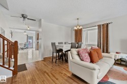 Living area featuring plenty of natural light, a chandelier, hardwood / wood-style floors, a ceiling fan, and a textured ceiling - 
