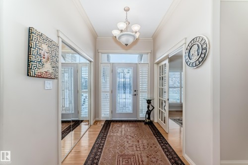 Entrance foyer with crown molding, a chandelier, and light wood-style floors - 241 Darlington Crescent, Edmonton, AB - Indoor Photo Showing Other Room