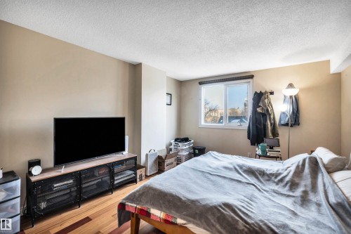 Bedroom featuring a textured ceiling and wood finished floors - 402 9929 113 Street, Edmonton, AB - Indoor Photo Showing Bedroom
