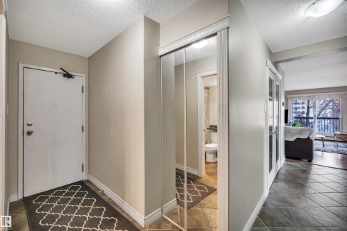 Entrance foyer featuring a textured ceiling and baseboards - 402 9929 113 Street, Edmonton, AB - Indoor Photo Showing Other Room