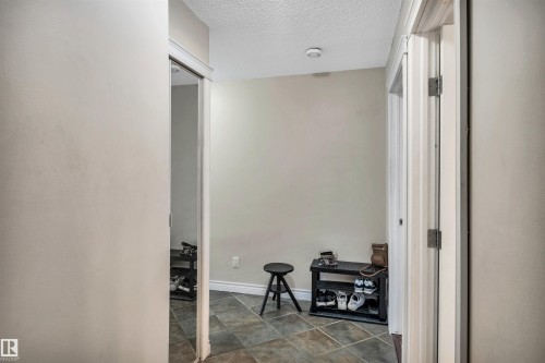 Corridor with a textured ceiling and baseboards - 402 9929 113 Street, Edmonton, AB - Indoor Photo Showing Other Room
