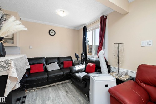 Living area with wood finished floors, crown molding, and a textured ceiling - 127 Cornell Court, Edmonton, AB - Indoor Photo Showing Living Room